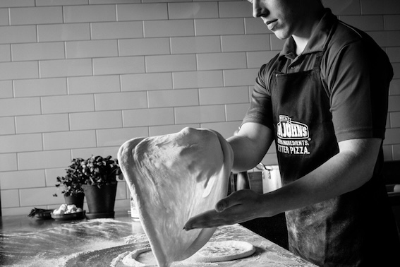 man stretching pizza dough