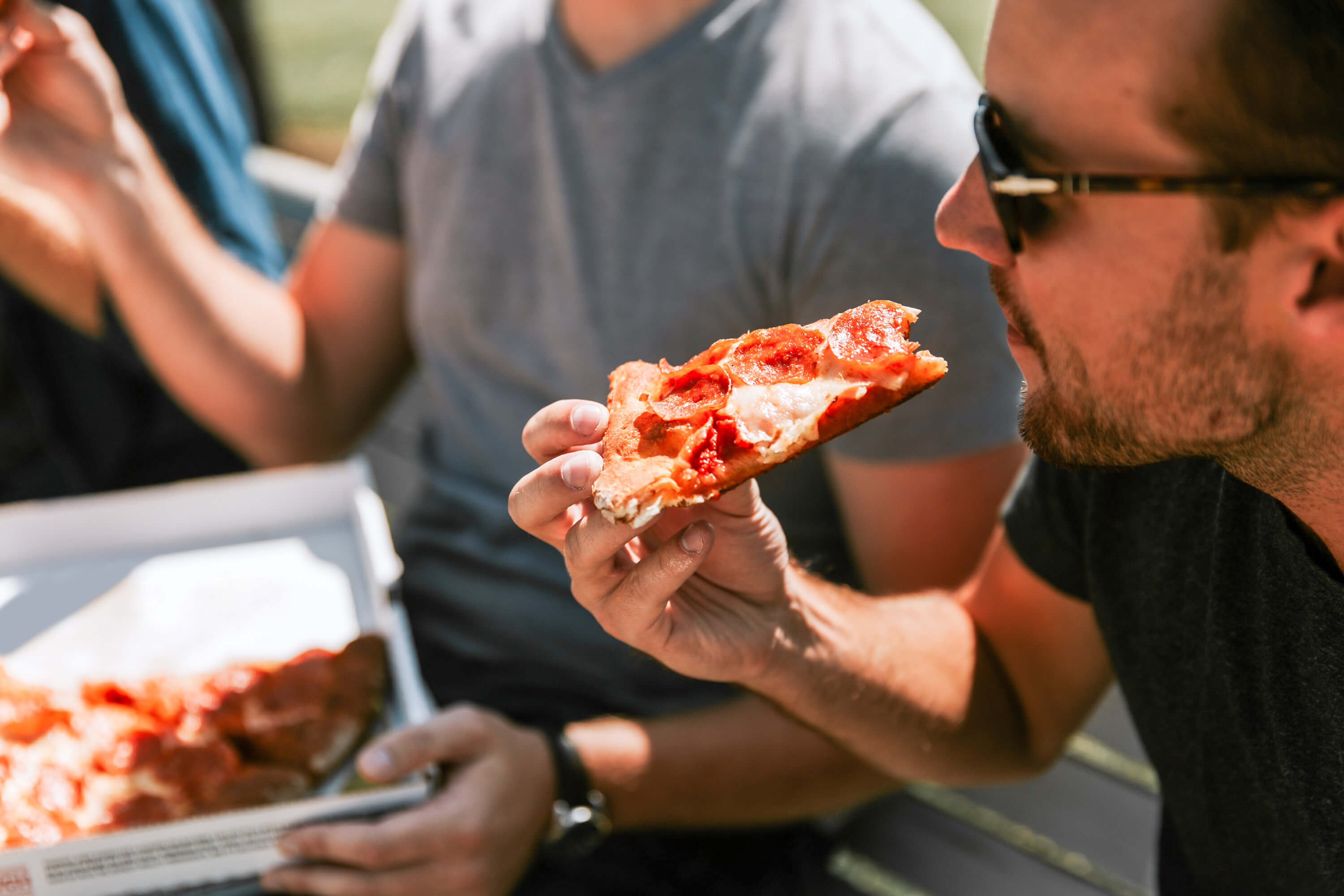 man eating a slice of pizza