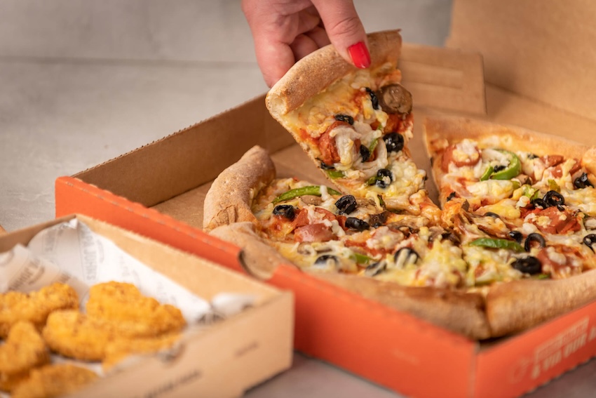 pizza slice being lifted out of box